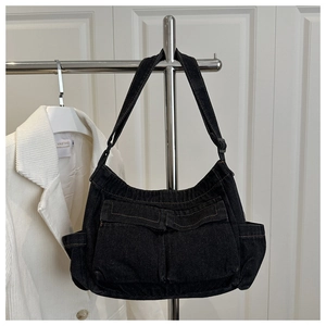 Detail of black denim crossbody bag with cargo pockets and adjustable shoulder strap