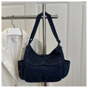 Detail of high-density dark blue denim tote bag with functional pockets and adjustable strap