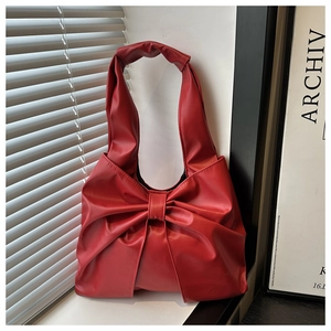 Nahaufnahme einer großen roten Handtasche mit Schleife aus hochwertigem Leder am Fenster