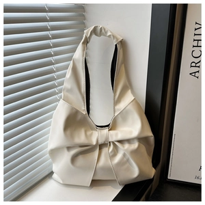 Nahaufnahme der cremefarbenen Schultertasche mit großer Schleife und Falten-Struktur