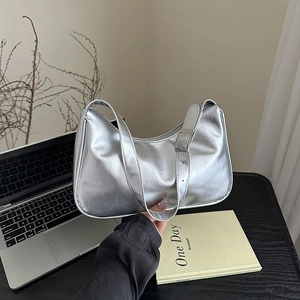 Silver metallic baguette underarm bag with adjustable strap in a lifestyle setting