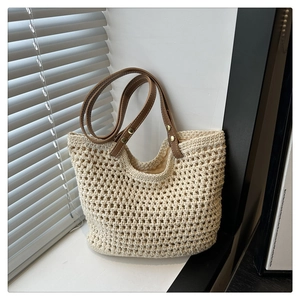 Détail du sac cabas en maille beige avec texture tissée et anses en cuir marron