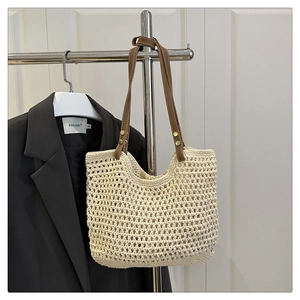 Detailaufnahme der handgefertigten Häkeltasche mit braunen Ledergriffen und Metallnieten