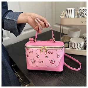 Pink cherry print handbag with gold zippers and adjustable shoulder strap detail