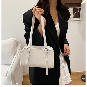 Detail of white leather shoulder bag with buckle straps and golden fashion lettering
