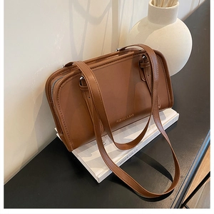 Close-up of caramel brown faux leather handbag with gold Fashion & Bag lettering detail