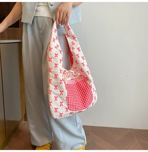 Detail of floral canvas tote with red ribbon print and lace-edged gingham pocket