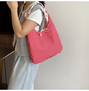 Close-up of red gingham tote bag with white drawstring closure and floral pattern lining
