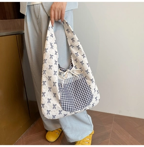 Detail of floral tote bag with blue bow prints and black checkered pocket on cotton canvas