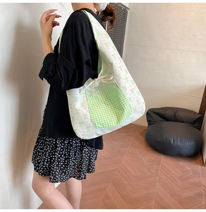 Detail of floral tote bag with green gingham pocket and decorative bow knot