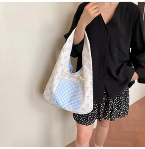 Detail of floral canvas tote bag showing blue bow print and lace edge pocket