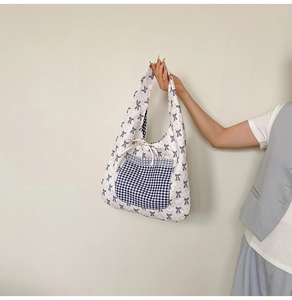 Detail of floral canvas tote bag with blue checkered pocket and bow tie decoration