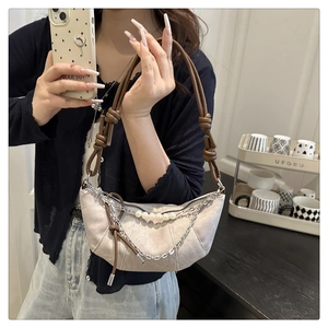 Dettaglio borsa croissant bianco sporco con perle oversize e accenti catena argento