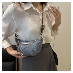 Dettaglio borsa a mezzaluna in denim con fili di perle e tracolla in pelle