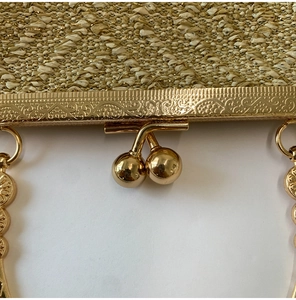 Detail of woven champagne gold evening bag with ornate vintage metal frame and clasp