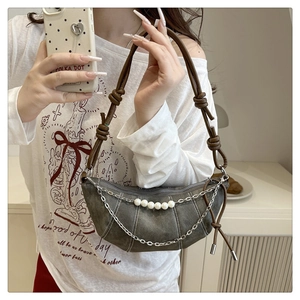 Dettaglio borsa a mezzaluna grigio scuro con catene argento, perle e tracolla marrone