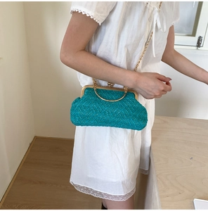 Detail of woven tweed bag in blue with golden handle and chain strap on a model