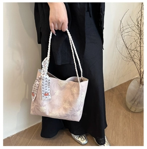 Détail du sac cabas floral en toile avec bandoulières tressées et accessoire foulard en soie
