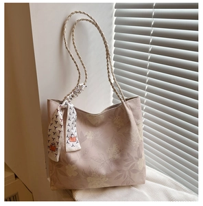 Détail de la broderie florale sur sac en toile avec accessoire de foulard décoratif en soie