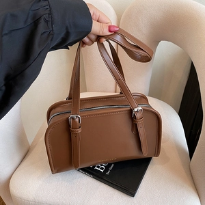 Brown leather rectangular handbag with decorative silver buckle straps and top handle