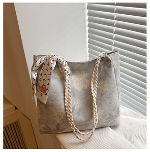 Détail du sac cabas gris à fleurs avec anses en corde tressée et foulard en soie