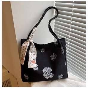 Détail de la broderie florale sur sac seau en toile noire avec poignée en foulard de soie