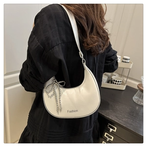 Detail of white crescent shoulder bag with silver beaded bow and Fashion print texture