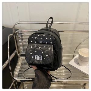 Détail du mini sac à dos noir matelassé avec strass et fermoir rotatif argenté