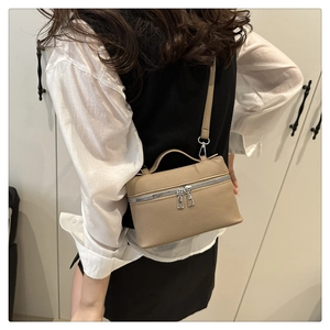 Detail of khaki litchi grain leather mini square bag with silver double zippers and handle