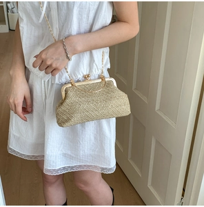 Detail of woven straw texture and gold metal frame on a retro-style evening clutch bag