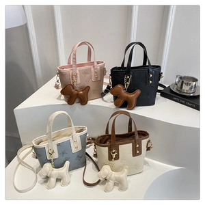 Detalle de los mini bolsos bombonera con relieve de mariposas y colgantes de perro