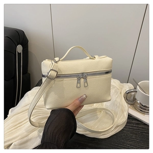 Macro detail of cream lychee texture leather on a stylish square crossbody bag with handle