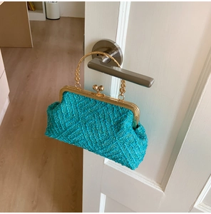 Detail of teal tweed woven bag with floral metal handle and vintage gold-tone clasp