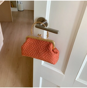 Detail of orange woven shell evening bag with vintage gold metal frame and ball clasp