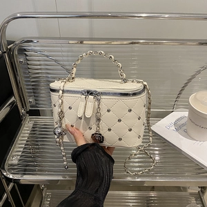 Sac à chaîne matelassé crème avec clous argentés et breloque camélia style lifestyle
