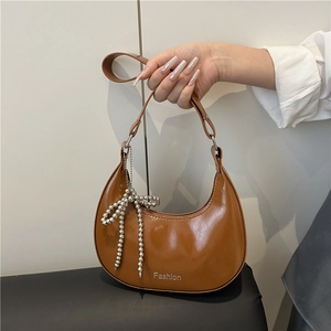 Caramel crescent hobo bag in glossy leather with silver beaded bow charm accessory