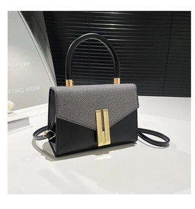Detail of trendy crossbody bag with tweed texture flap and golden hardware accents