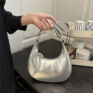 Metallic silver crescent moon handbag with fashion logo and beaded bow pendant