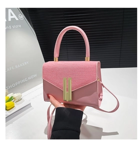 Detail of pink leather handbag with woven flap and vertical gold metal clasp