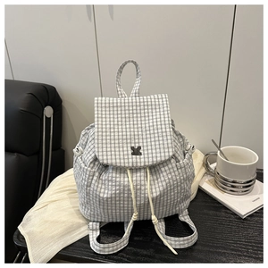 Detailed view of checkered drawstring backpack with flap closure and side pockets