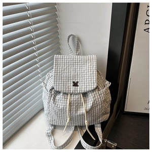 Close-up of light gray checkered drawstring backpack with flap and metal buckle detail