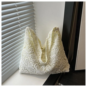 Gros plan de la dentelle florale et du motif ajouré sur le sac fourre-tout blanc chic