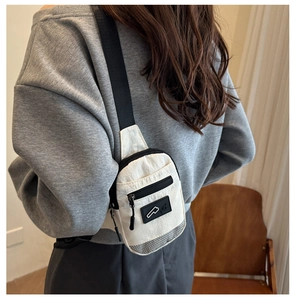 Rear view of a model wearing a chic off-white canvas chest bag with zipper and logo