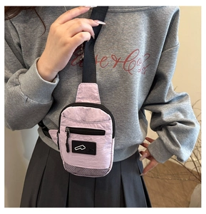 Detail of pink ruched crossbody chest bag with black zipper pocket and mesh paneling
