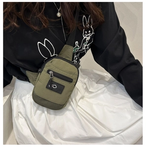 Detail of army green nylon chest bag featuring front mesh pocket and adjustable strap