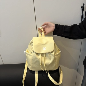 Pale yellow drawstring fashion backpack with flap closure and geometric logo for daily use