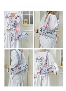 Detailansicht der hellblauen Handtasche mit roten Schleifen und Herzanhänger am Model