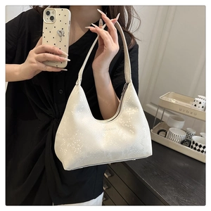 Detail of white half-moon shoulder bag with starry texture and Fashion Bags print