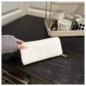 Détail du grand portefeuille blanc zippé en similicuir texturé avec finitions dorées