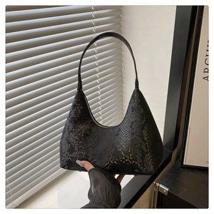 Detail of black snake-textured hobo bag showing faux python leather and metal zipper